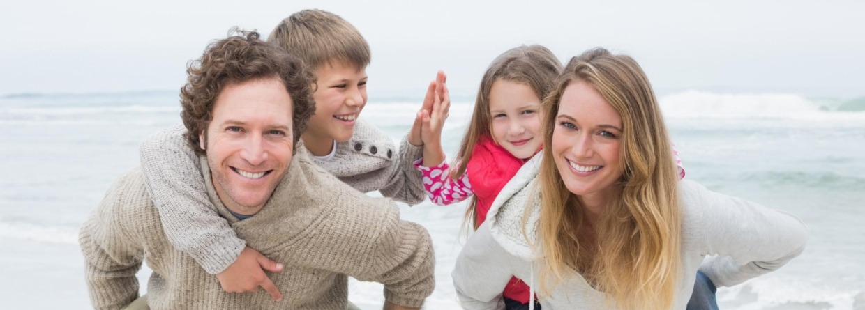 Gezin op het strand ouders met kinderen op hun rug