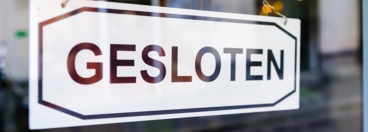 Een bordje op een raam met de tekst 'Gesloten'