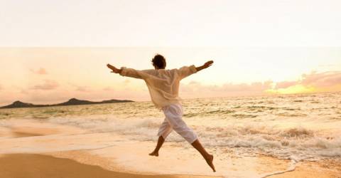 man huppelt over het strand