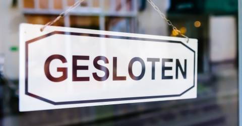 Een bordje op een raam met de tekst 'Gesloten'